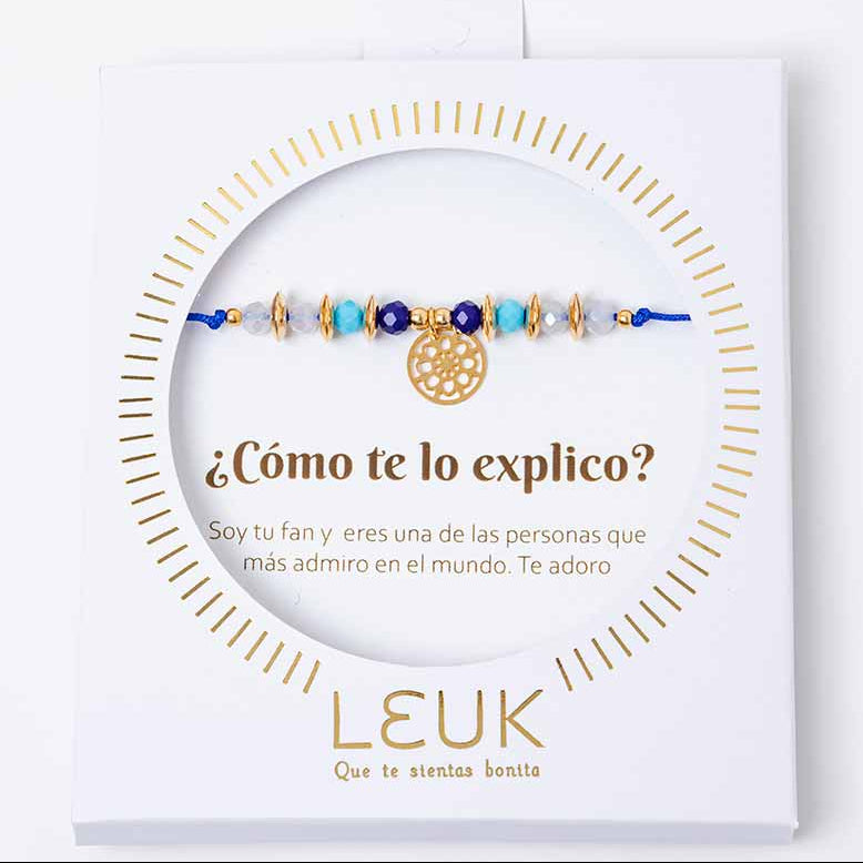 A bracelet with blue and gold colors presented in a packaging with a question ' Como te lo explico?' and the brand name LEUK.