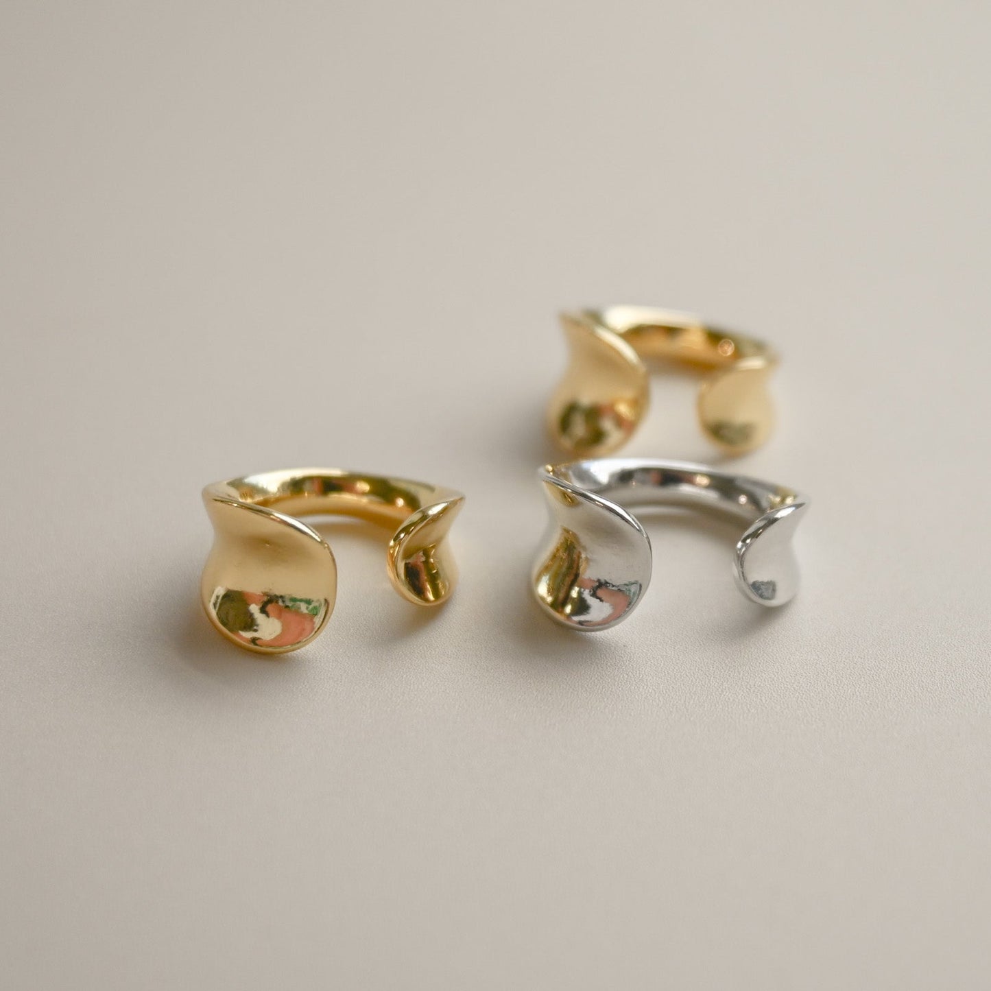 A pair of gold-colored hoop earrings with a glossy finish on a white background.