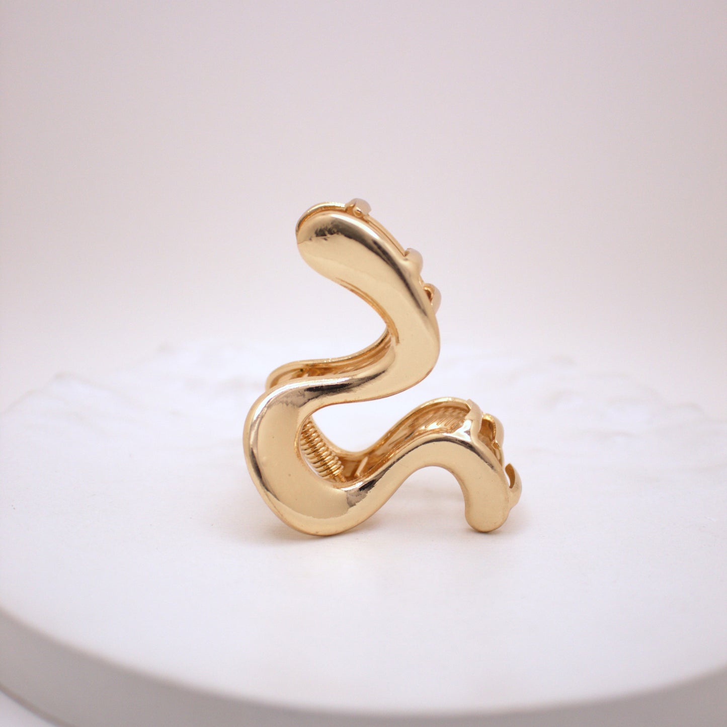 Gold snake-shaped Hair clip on a white background