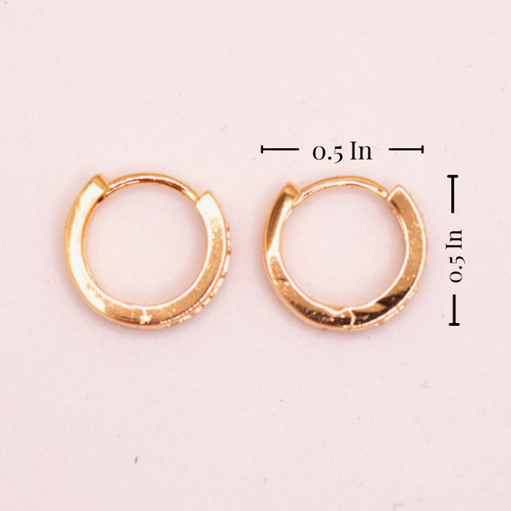 Gold hoop earrings with measurements on a light pink background