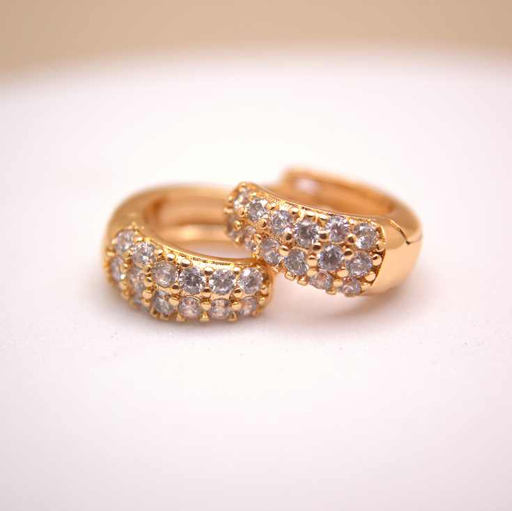 Pair of gold rings with diamond accents on a light background