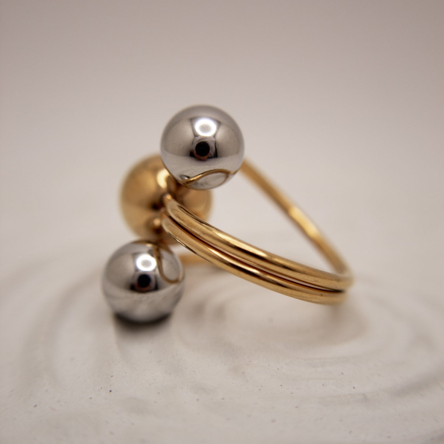 Gold and silver ring on a light gray background