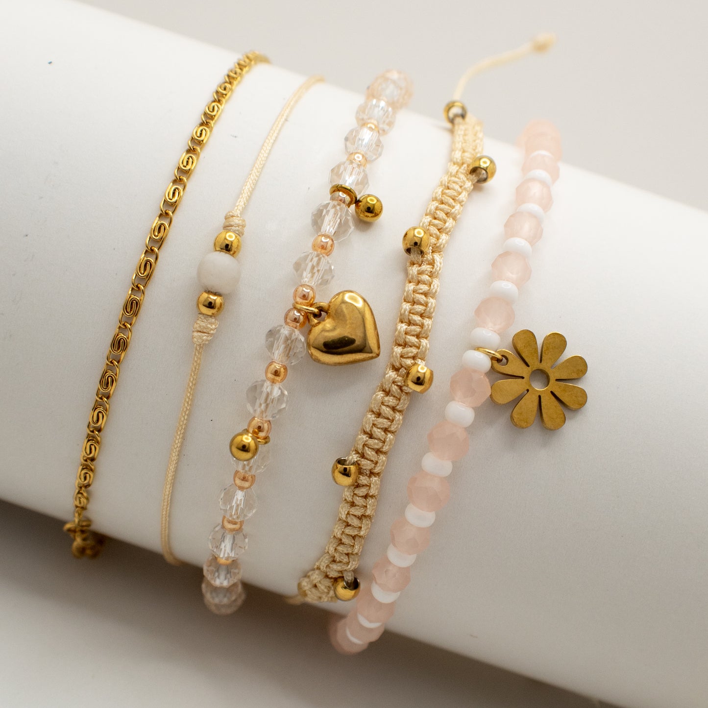 Set of gold and beaded bracelets on a white surface