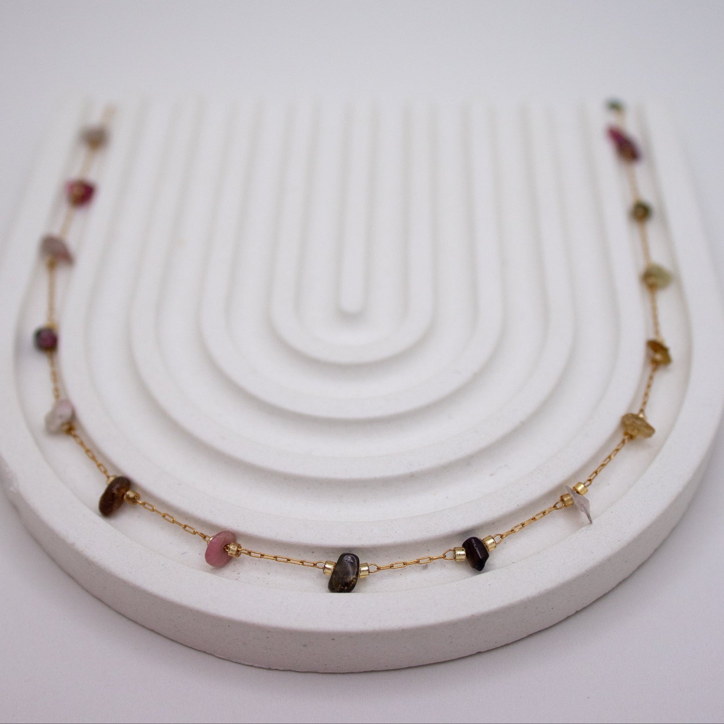 Necklace with gemstones on a white stand