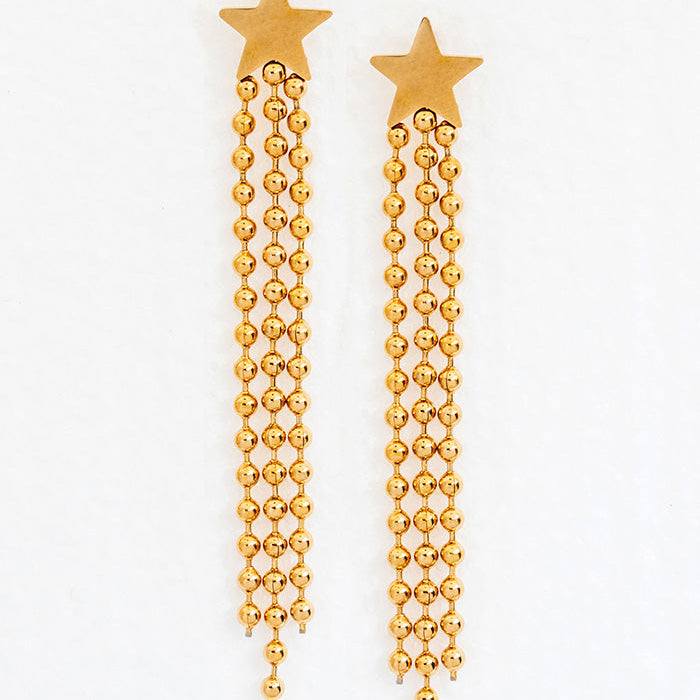 A pair of gold-colored earrings with a star motif and cascading strips, displayed against a white background.