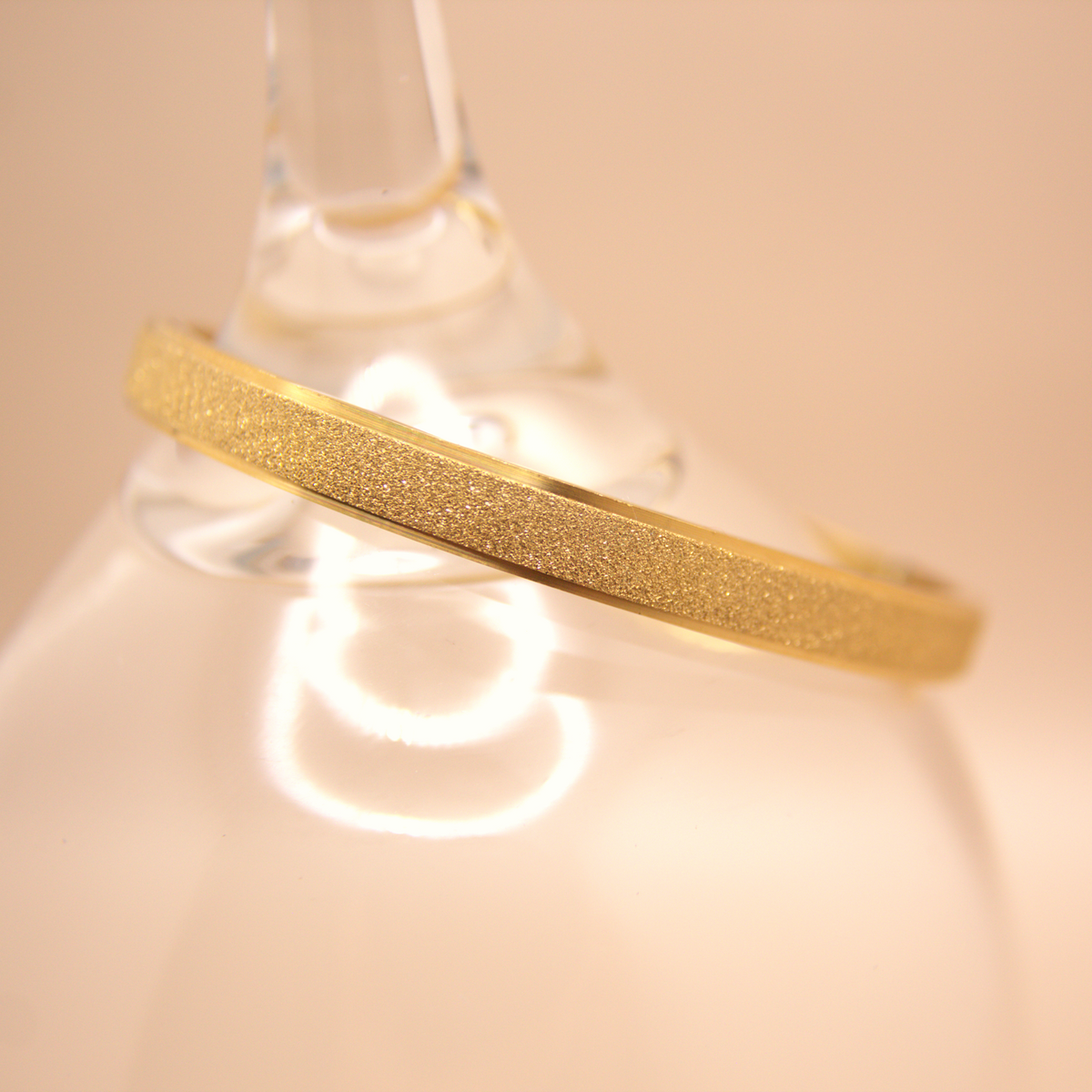 Gold bangle bracelet with sparkly textured finish, PVD stainless steel.