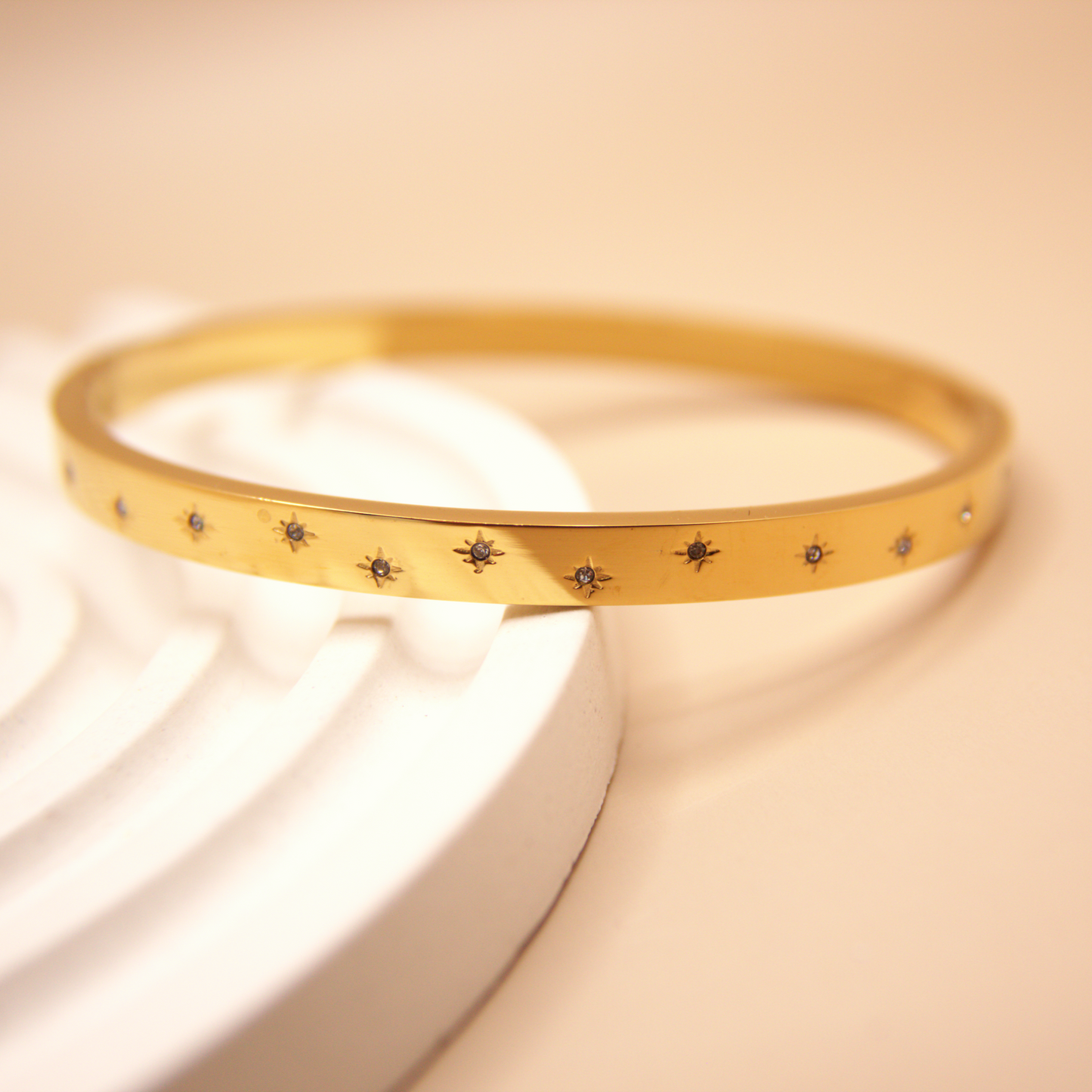 Gold bangle bracelet with engraved star details, PVD stainless steel.