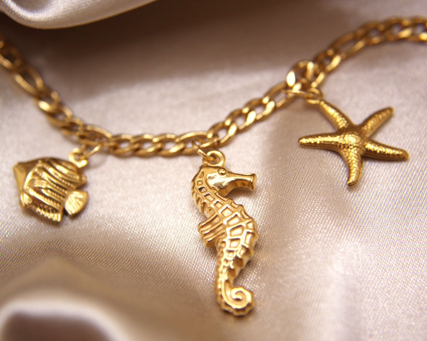 Gold bracelet with seahorse, fish, and starfish charms by Selva Accessories