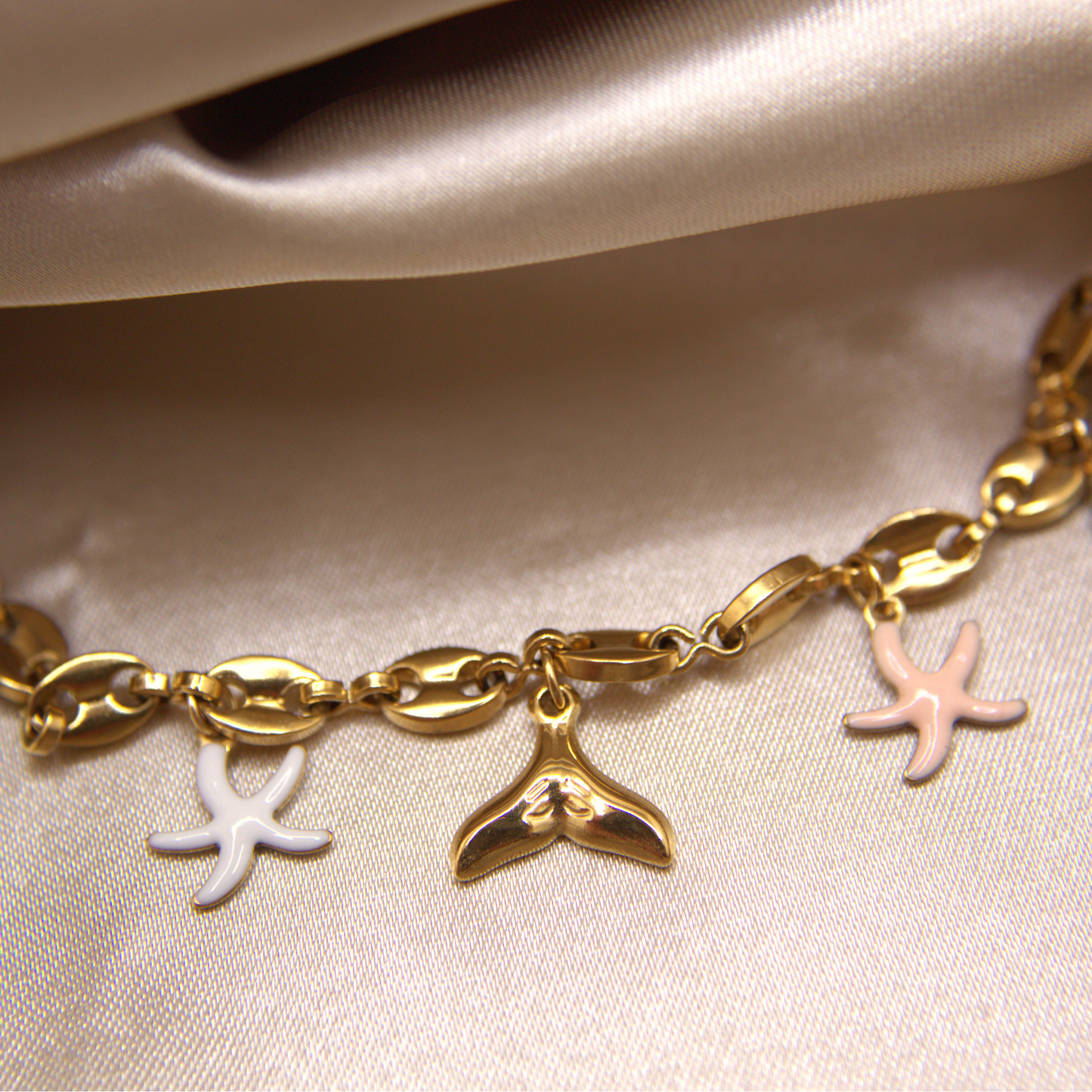 Sea Whisper Bracelet in gold with whale tail, starfish, and natural stone charms