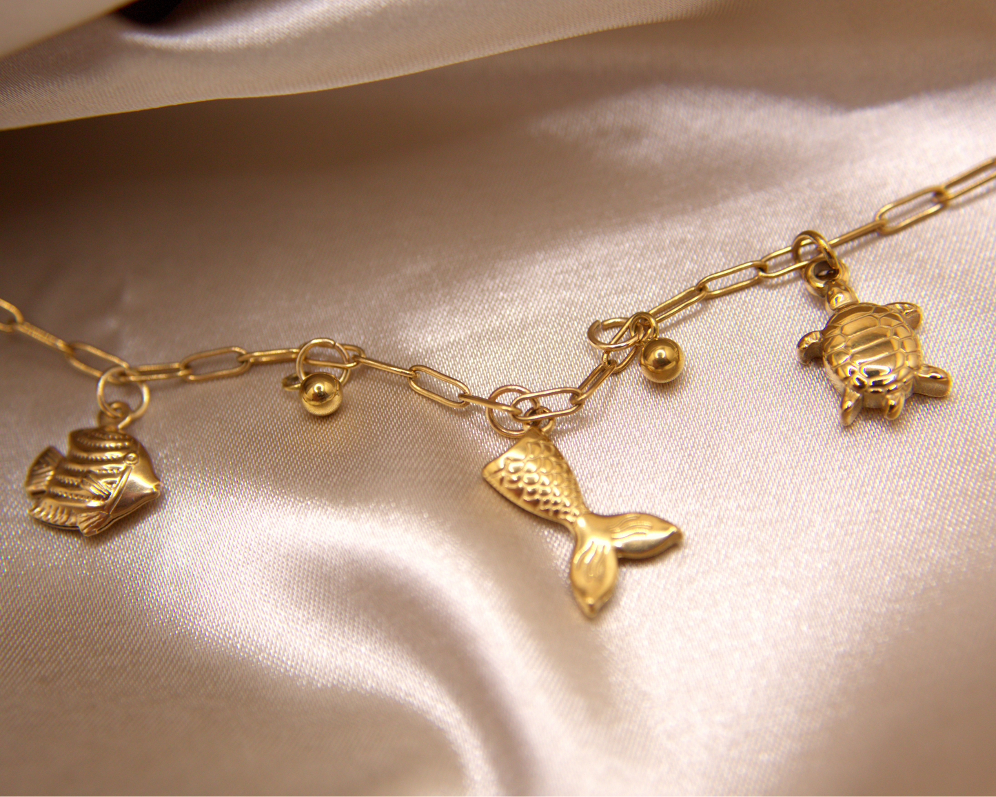 Mermaid Dreams Bracelet with turtle, fish, and mermaid tail charms in gold
