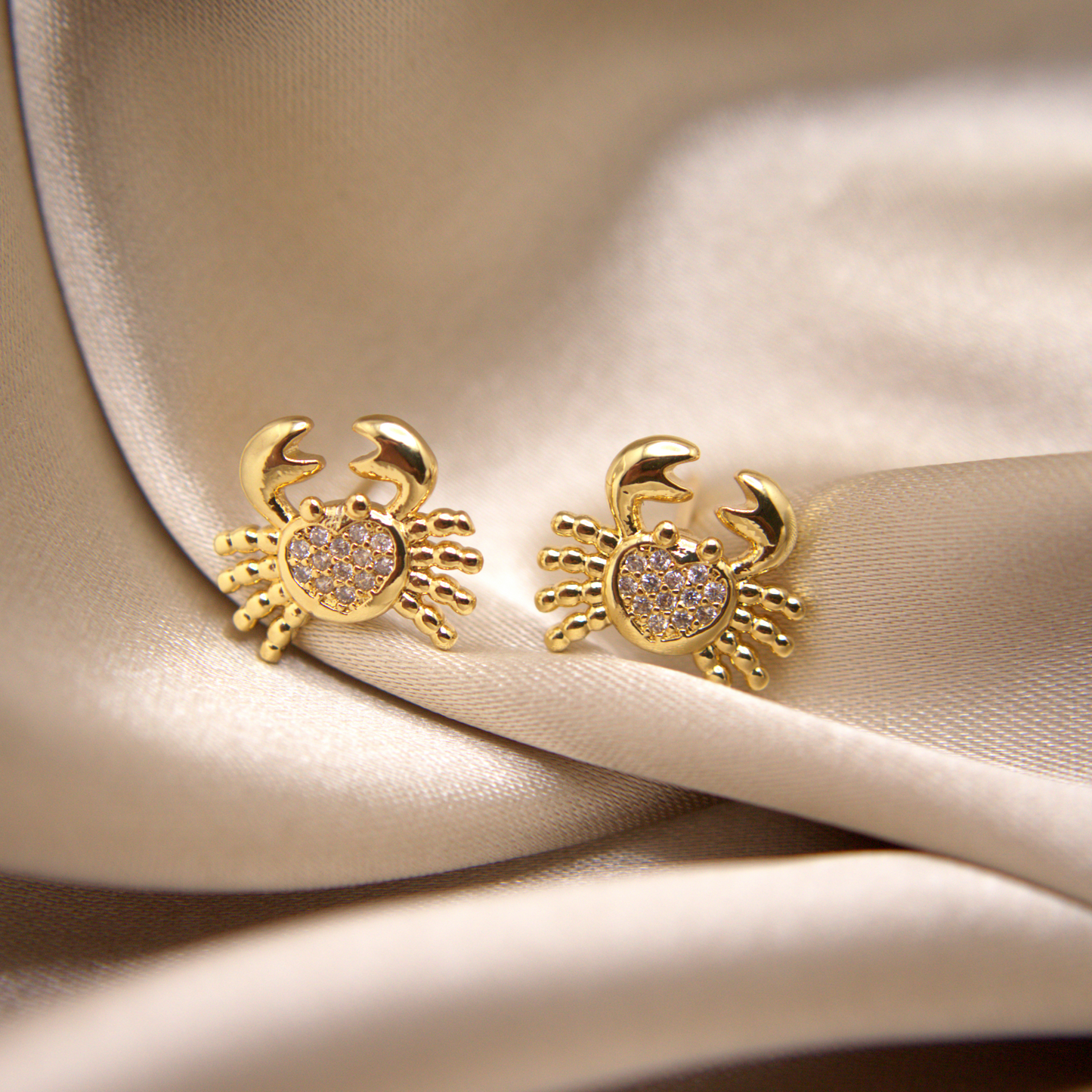 Golden crab earrings symbolizing strength and joy, with a luxury finish