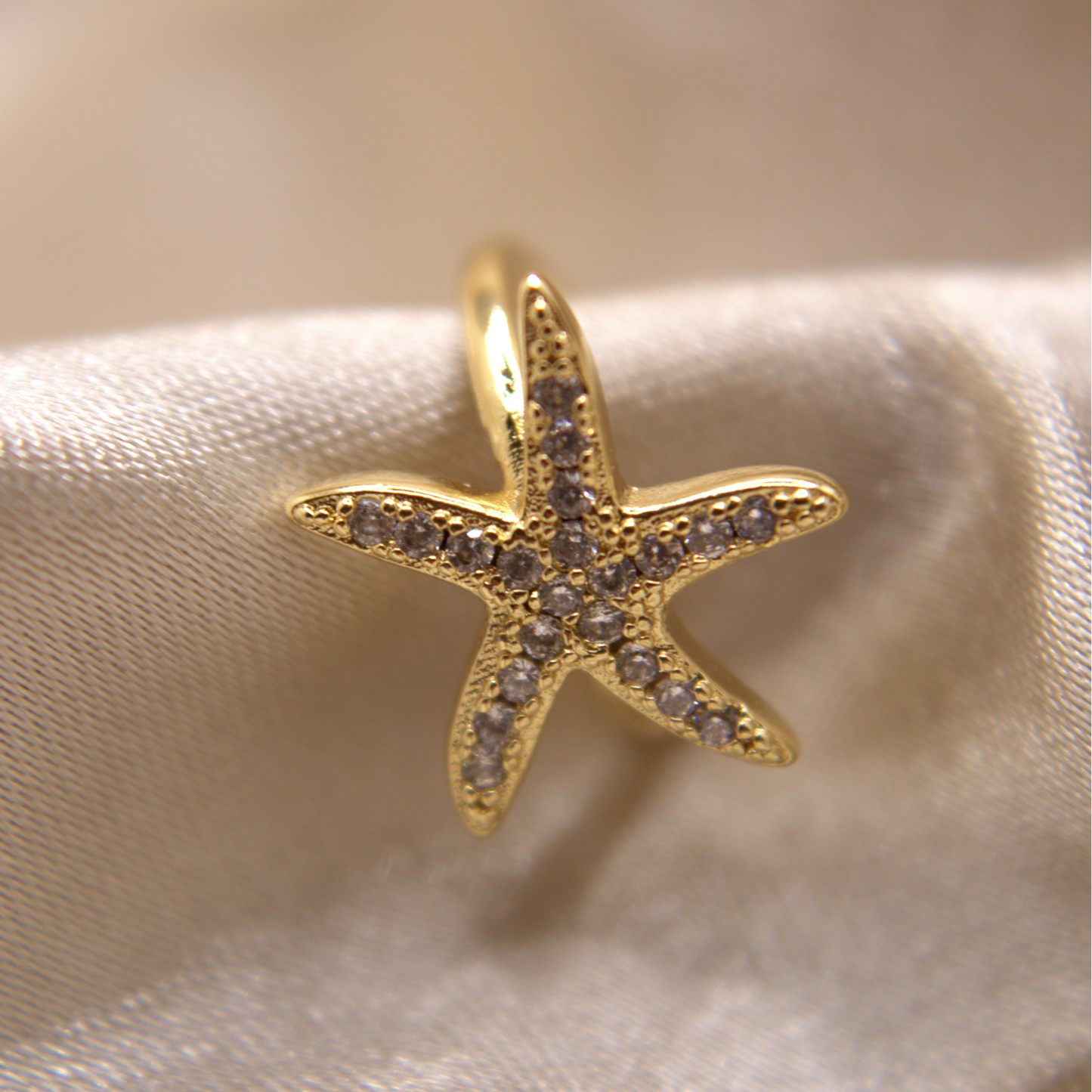 Ocean-inspired ear cuff in gold with sparkling details.