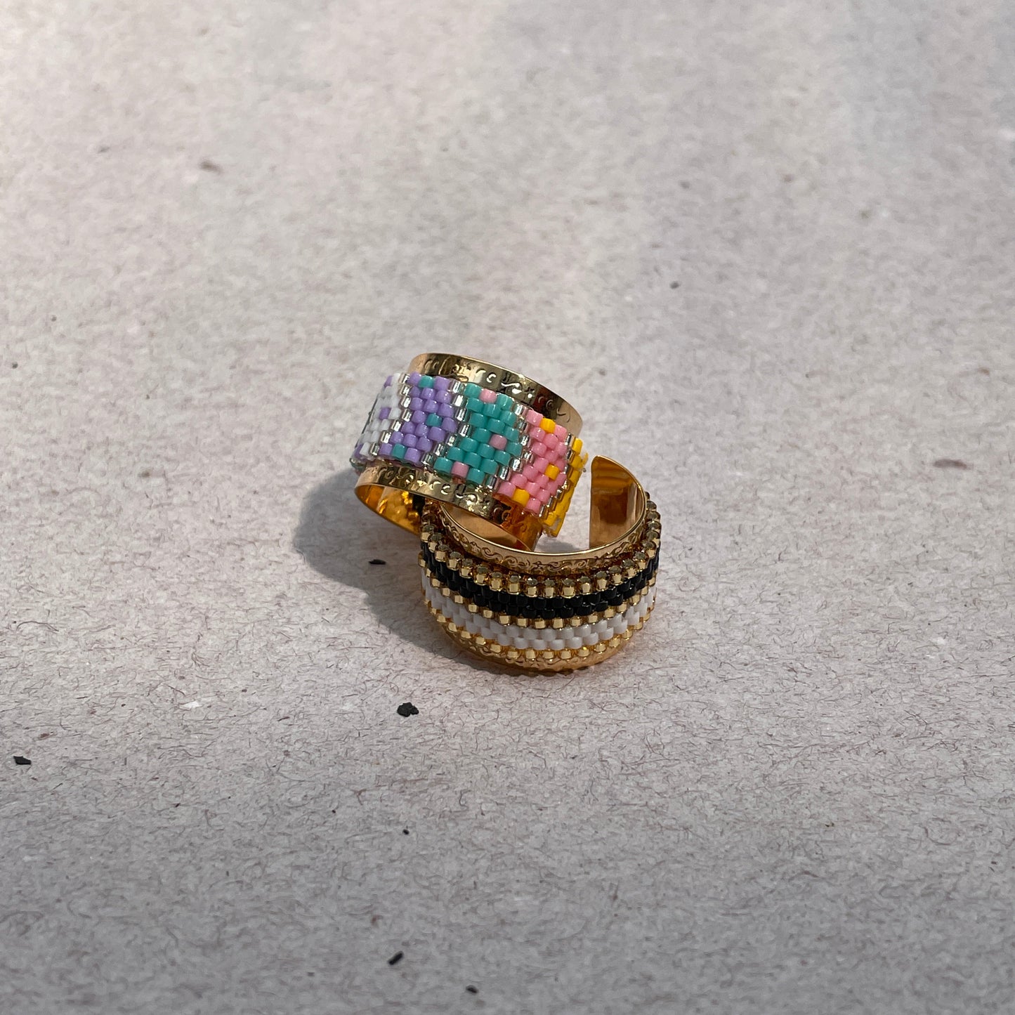 Multicolored beaded ring on a textured gray surface
