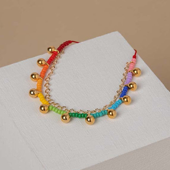 An adjustable ankle bracelet with gold plated appliques, showcased on a white surface.