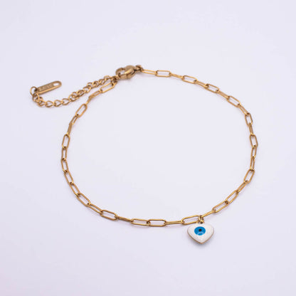 A gold paperclip chain anklet with an adjustable lobster clasp and extender chain, featuring a small white heart charm with a blue and black evil eye design, displayed on a clean white background.