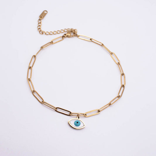 Gold paperclip chain anklet with a small evil eye charm featuring a turquoise blue center, displayed on a clean white background.