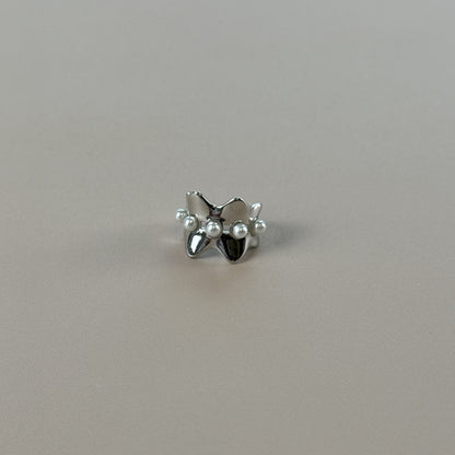 Silver earcuff with pearls on a gray background