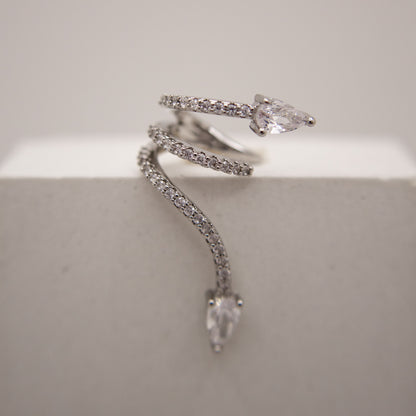 Silver snake-shaped ear cuff with clear gemstones on a light gray background