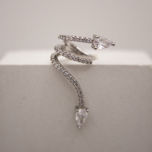 Silver snake-shaped ear cuff with clear gemstones on a light gray background