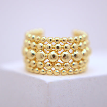 Gold beaded ear cuff on a white background