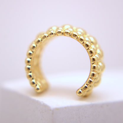 Gold hoop earring on a white background
