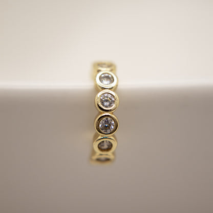 Gold ear cuff with  diamonds on a reflective surface