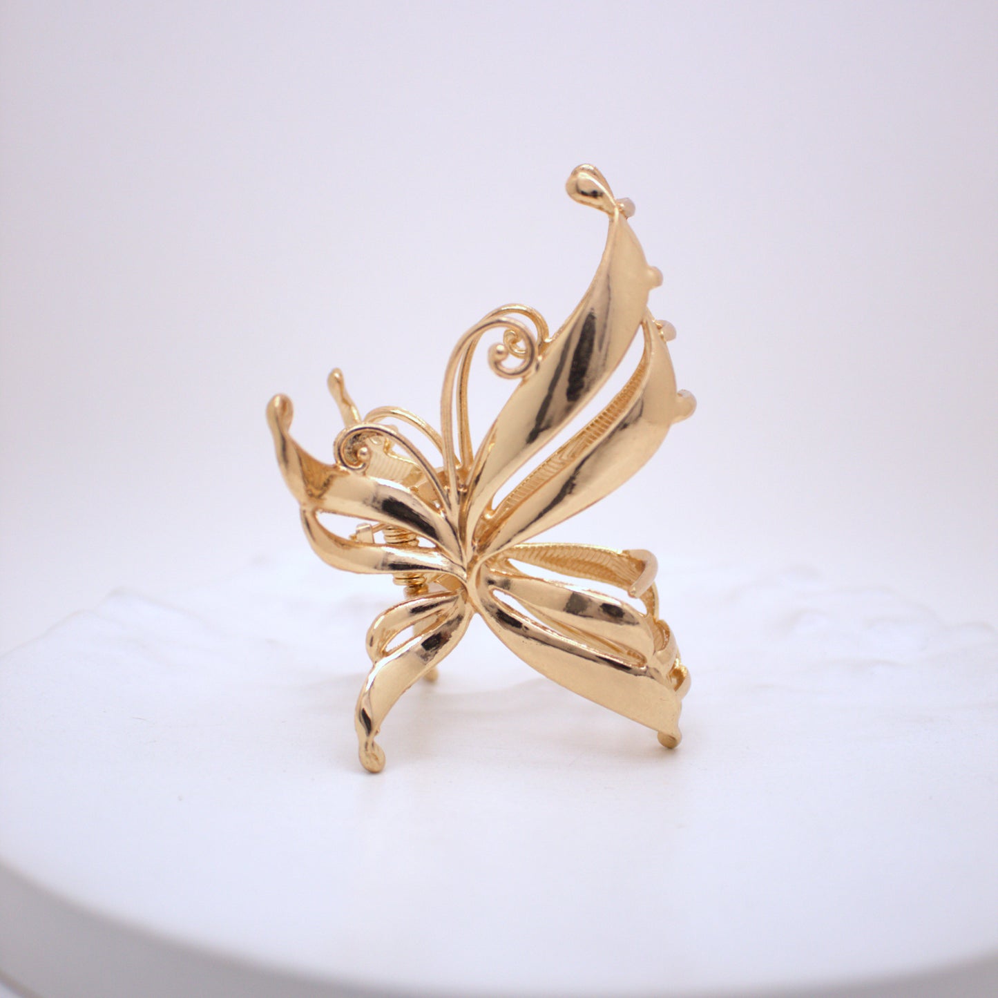 Gold butterfly-shaped brooch on a white background