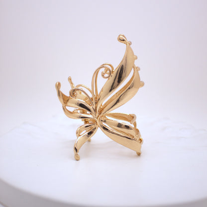 Gold butterfly-shaped brooch on a white background