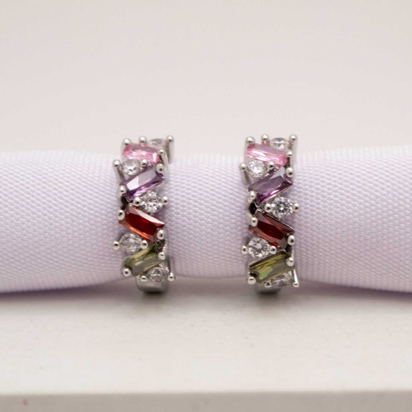 Pair of earrings with colorful gemstones on a white background
