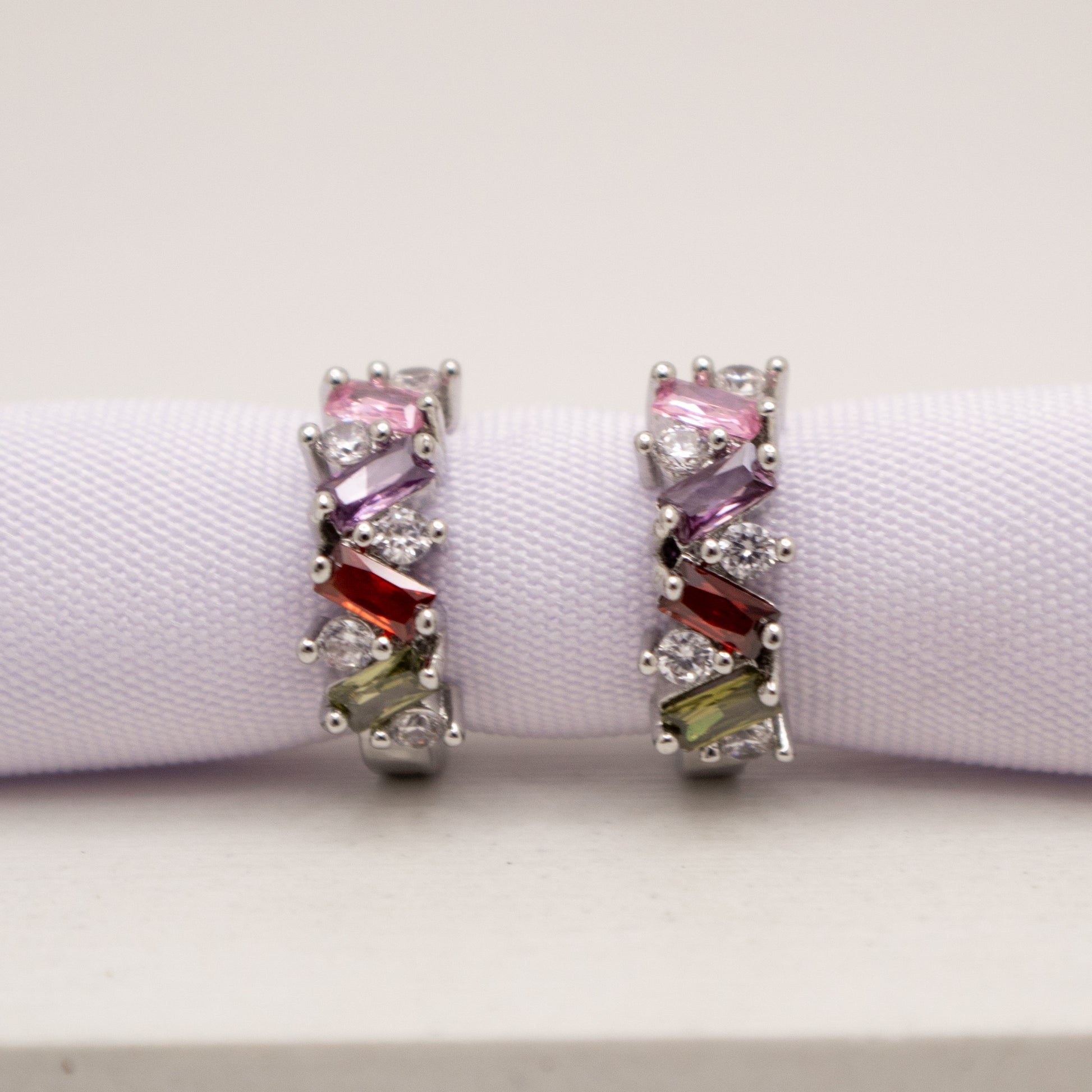Pair of earrings with colorful gemstones on a white background