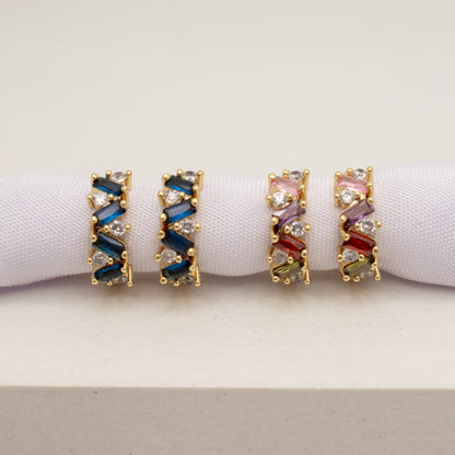 Pair of gold hoop earrings with colorful gemstones on a white background