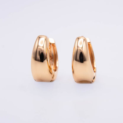 A pair of polished rose gold huggie hoop earrings shown from a side profile view against a clean, light gray background.
