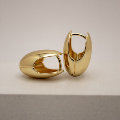 Pair of gold hoop earrings on a light gray background
