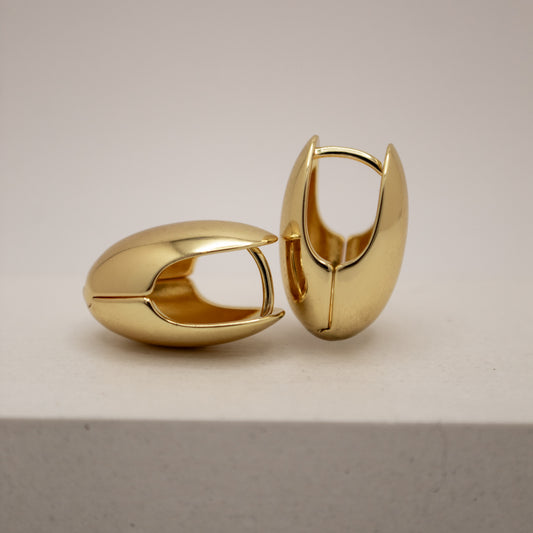Pair of gold hoop earrings on a light gray background