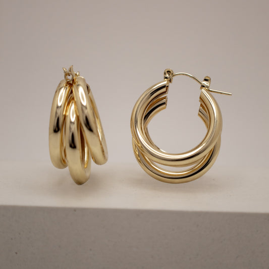 Pair of gold hoop earrings on a neutral background
