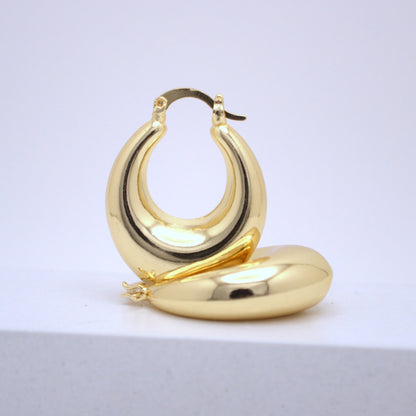 Gold hoop earrings on a light gray background