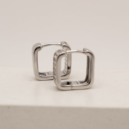 Pair of silver hoop earrings on a light gray background