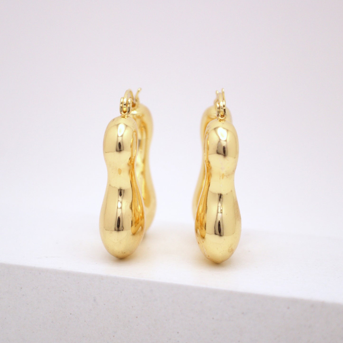 Pair of gold hoop earrings on a white background