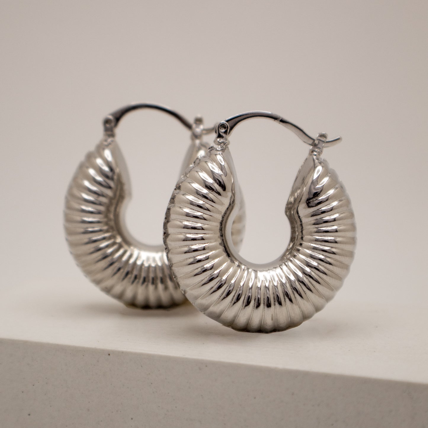 Silver hoop earrings on a light gray background