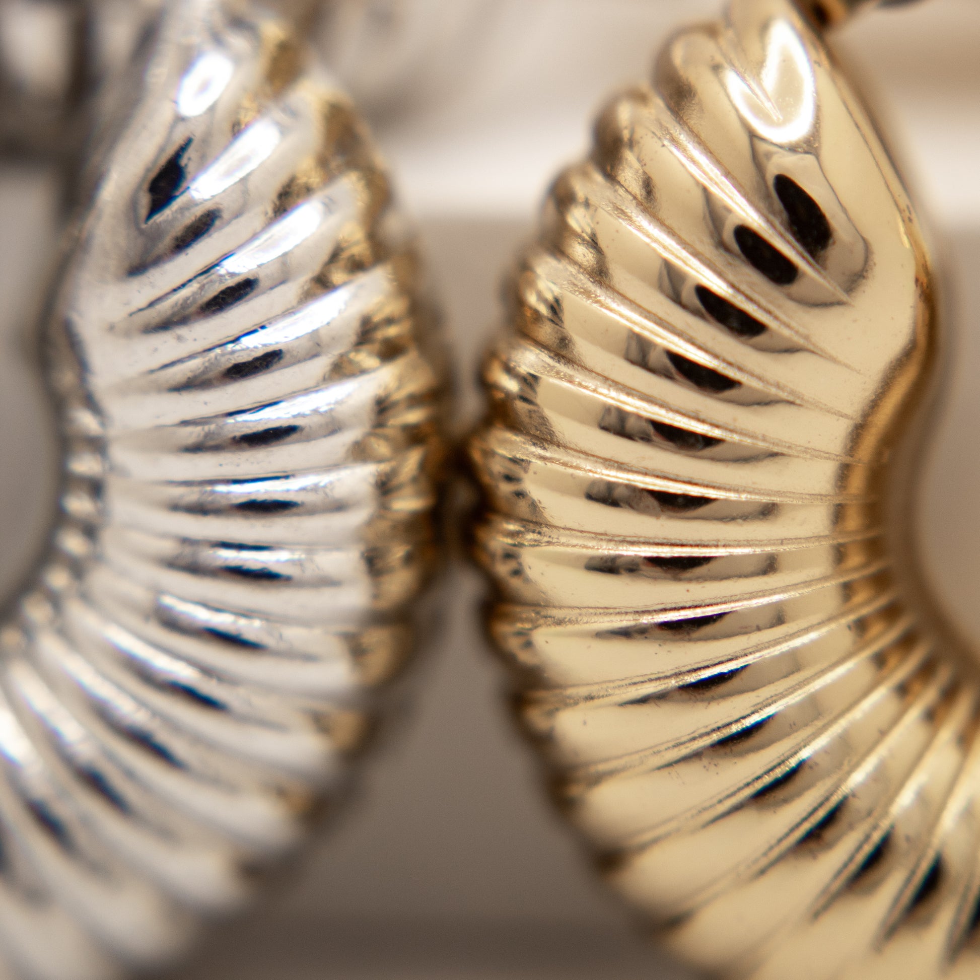 Close-up of gold and silver leaf-shaped earrings.
