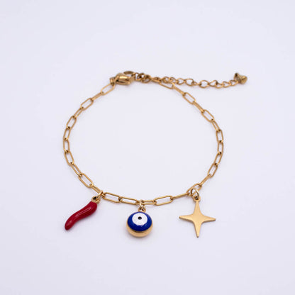 A gold chain bracelet with three charms: a red italian horn, a blue and white evil eye bead, and a gold star, displayed on a clean white background.