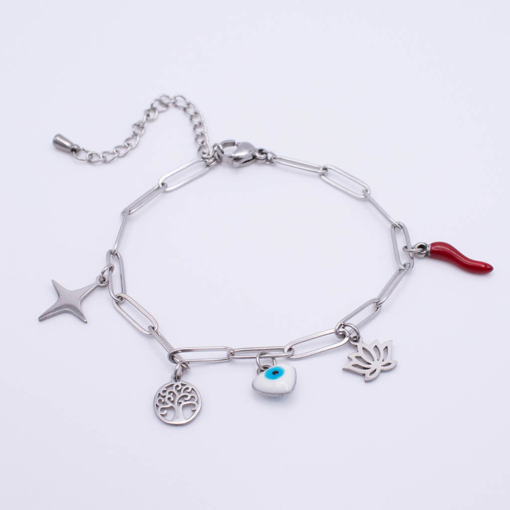 A silver paperclip chain bracelet with multiple charms, including a star, a tree of life, an evil eye heart, a lotus flower and a red italian horn, shown on a plain white background.