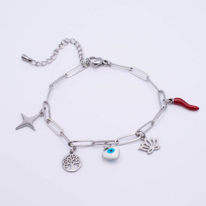 A silver paperclip chain bracelet with multiple charms, including a star, a tree of life, an evil eye heart, a lotus flower and a red italian horn, shown on a plain white background.