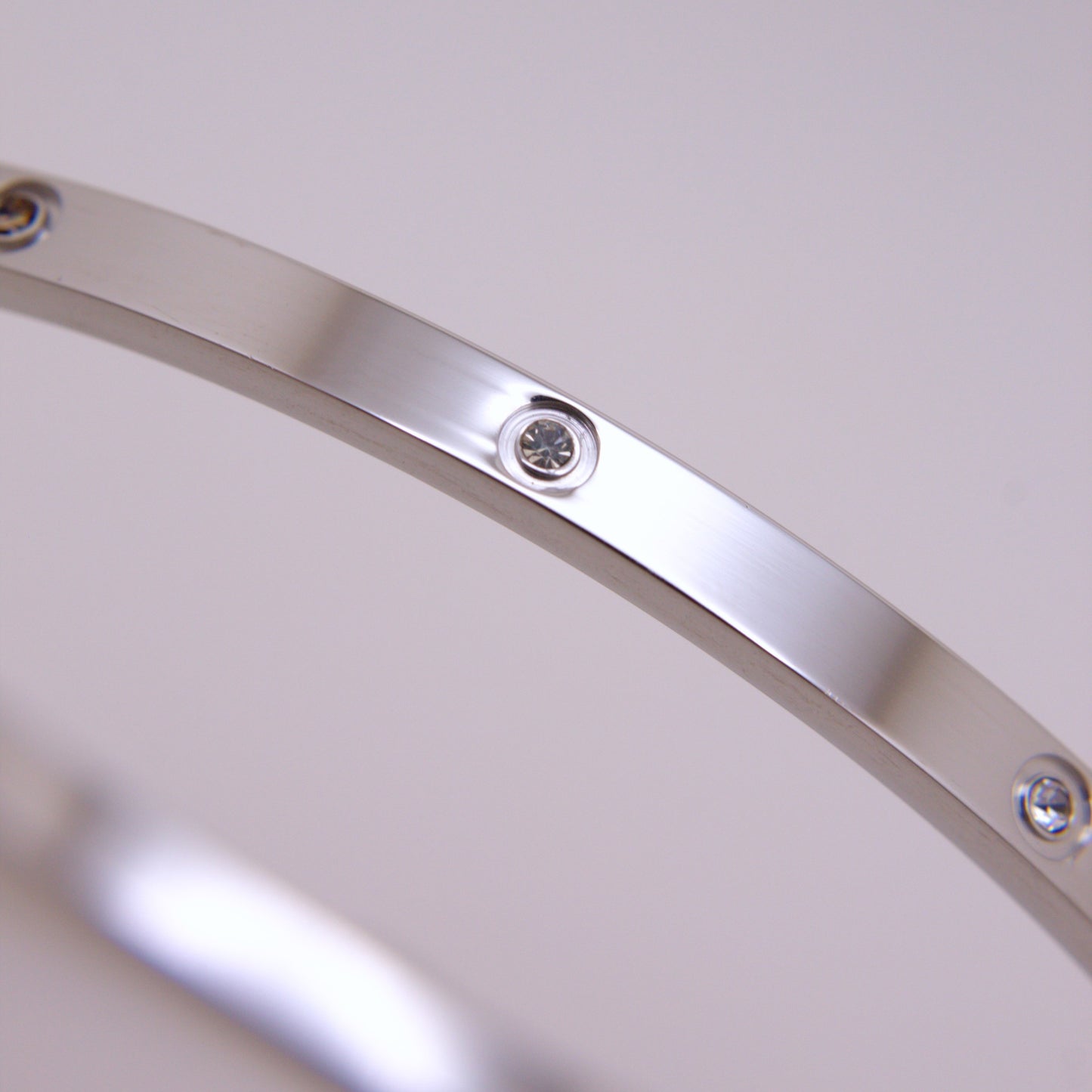 Close-up of a silver bracelet with crystals on a light gray background
