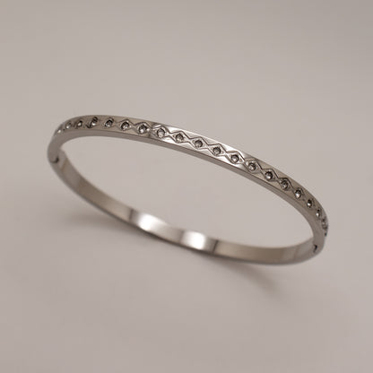 Silver ring with small stones on a light gray background