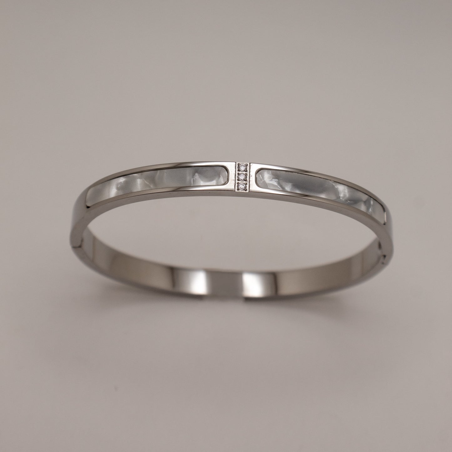 Silver bracelet on a light gray background