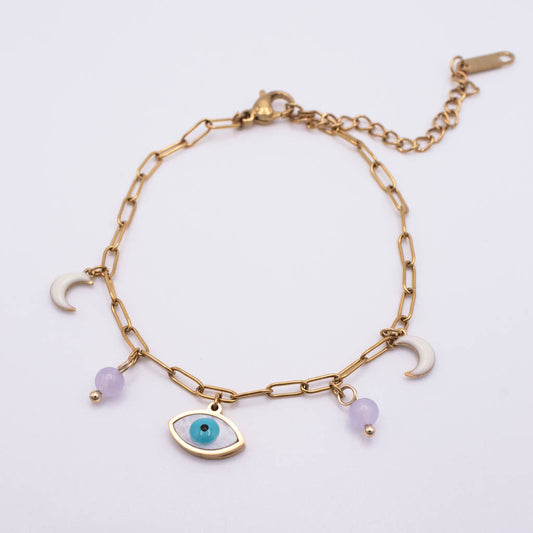 Gold chain anklet featuring a central gold and turquoise evil eye charm, flanked by two white crescent moon charms and two small light purple beads, displayed on a clean white background.