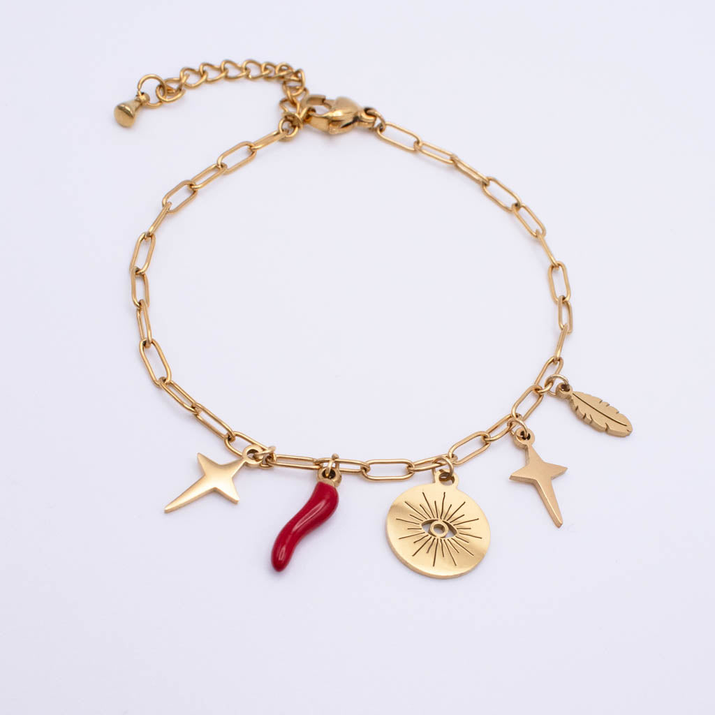 A gold paperclip chain bracelet with four dangling charms: a gold star, a red Italian horn a round gold sunburst disc with an eye motif, and a gold feather.