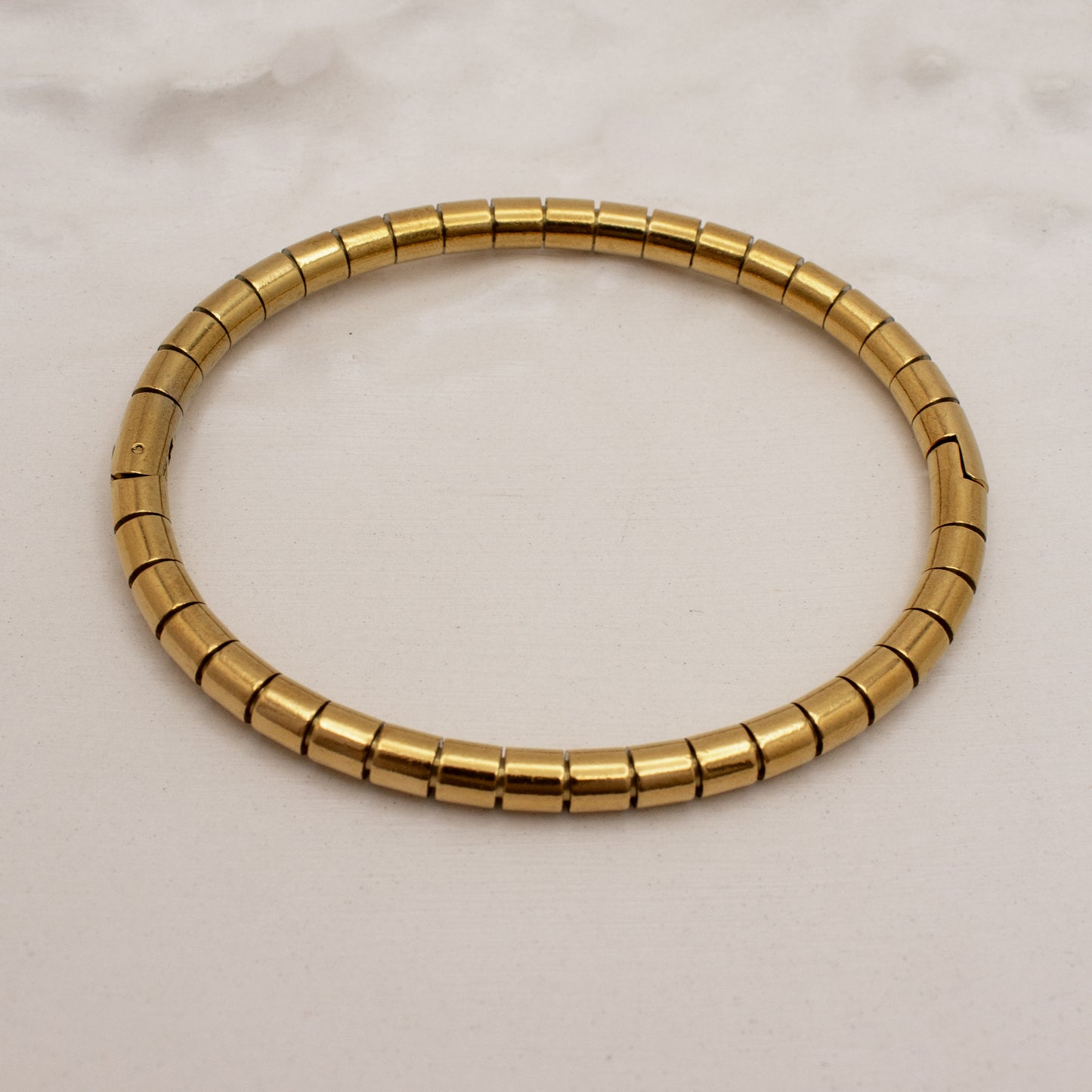 Gold bracelet on a light beige background