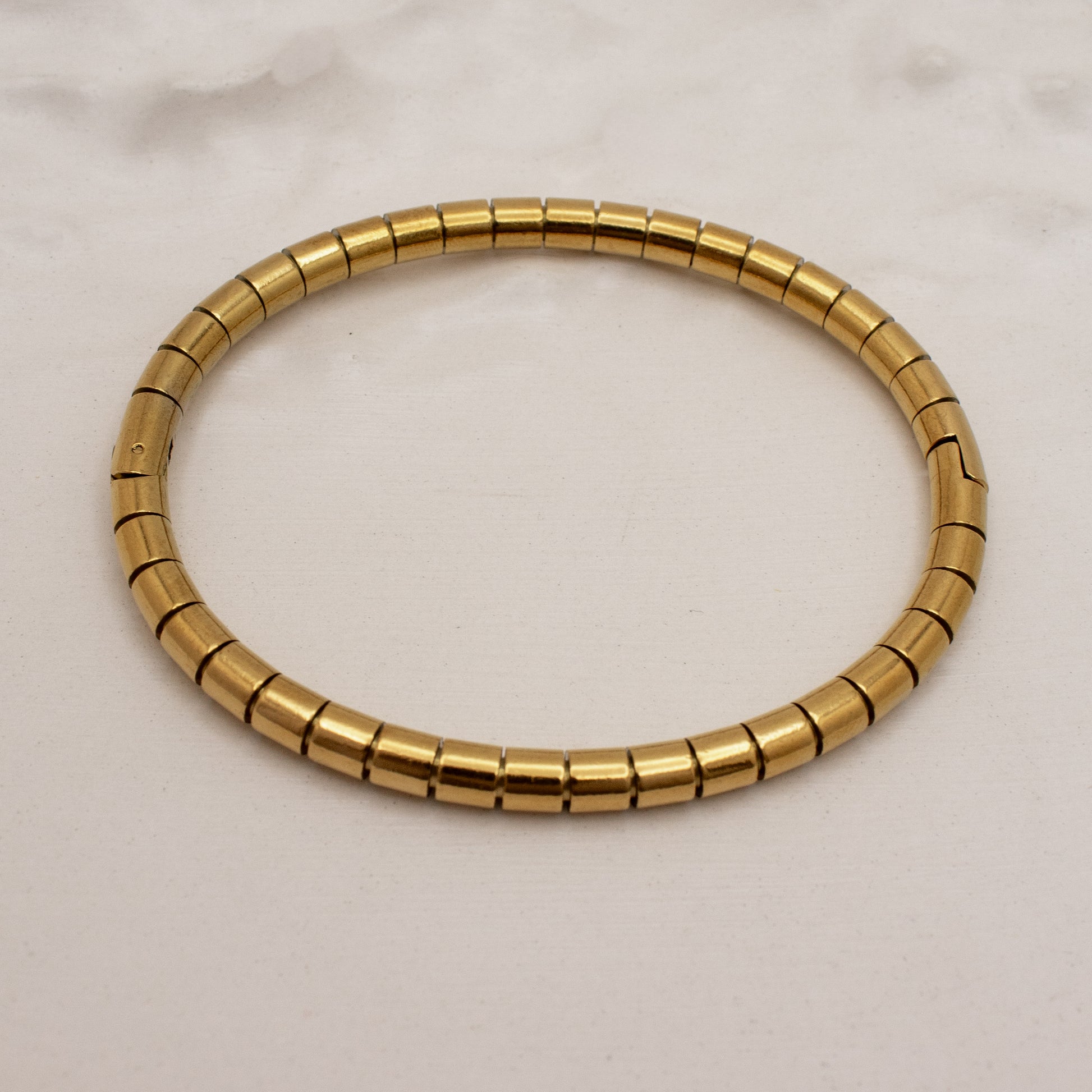 Gold bracelet on a light beige background